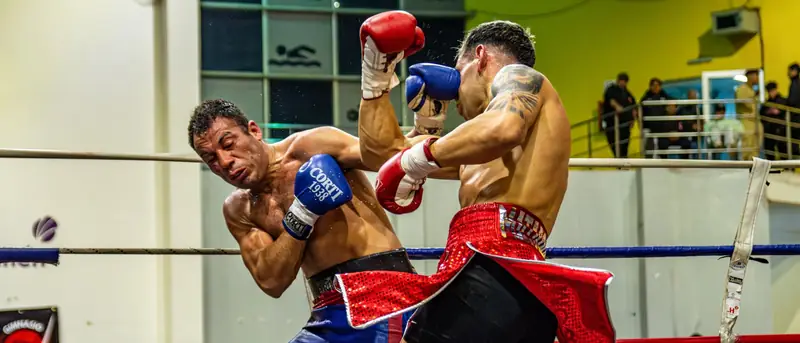 Two boxers trade shots in front of a full crowd